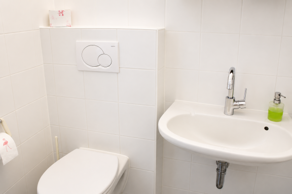 Saubere Toilette und modernes Waschbecken in einem hellen Badezimmer.